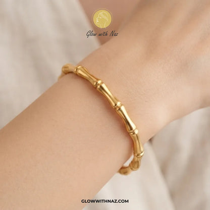 Gold bone segment link cuff bangle worn on model wrist by Glow With Naz
