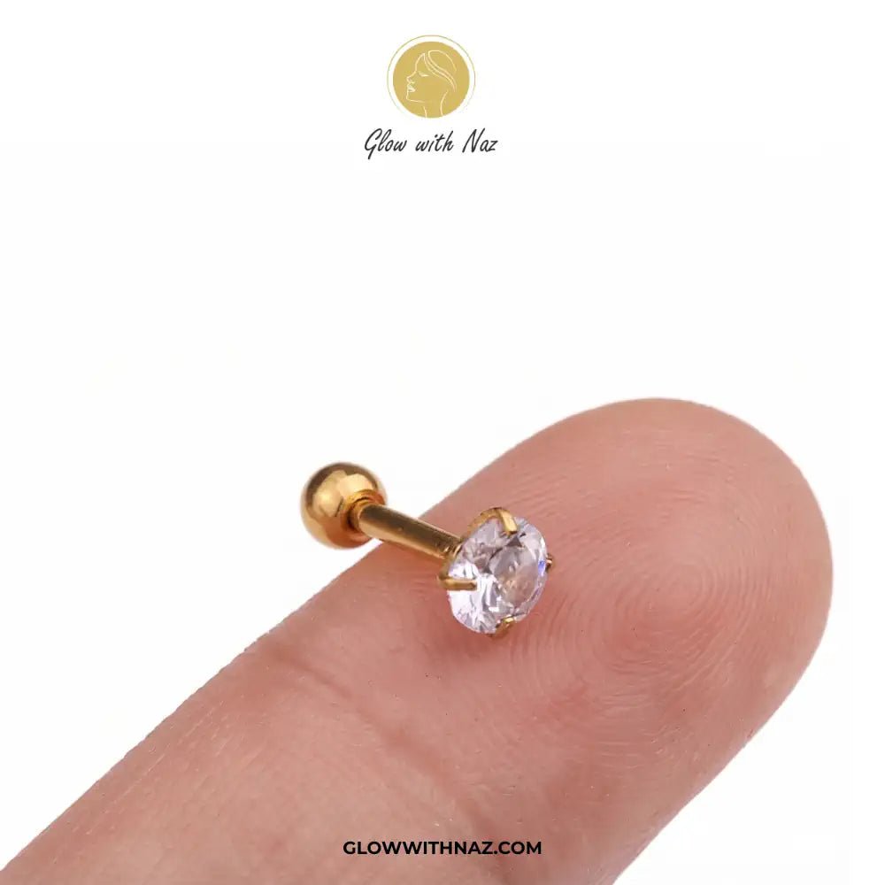 Diamond Zircon Nose Pin & Helix Piercing Jewelry - Diamond Zircon Nose Pin & Helix Piercing JewelryJewelryGlow With NazGlow With NazNR007A gold-plated labret stud piercing with a clear round-cut gemstone, shown resting on a person's fingertip against a white background. The brand logo 'Glow with Naz' is visible at the top and the URL diamond nose pin, helix piercing jewelry, stainless steel nose stud, zircon nose ring, Glow With Naz jewelry, viral trending piercing, cartilage piercing, body jewe