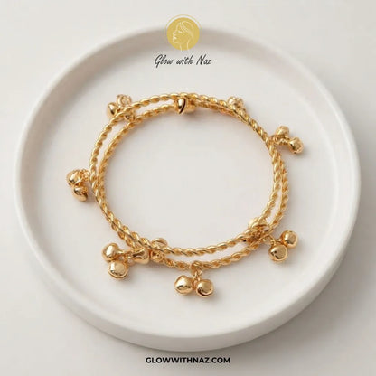 Gold Kashmiri twisted rope ghungroo bangle set of 2 on ceramic dish by Glow With Naz