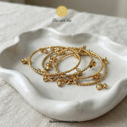 Set of 4 gold Kashmiri ghungroo bangles in decorative ceramic dish by Glow With Naz