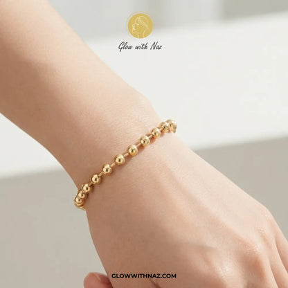 Minimalist gold sphere bead chain bracelet worn on model wrist by Glow With Naz
