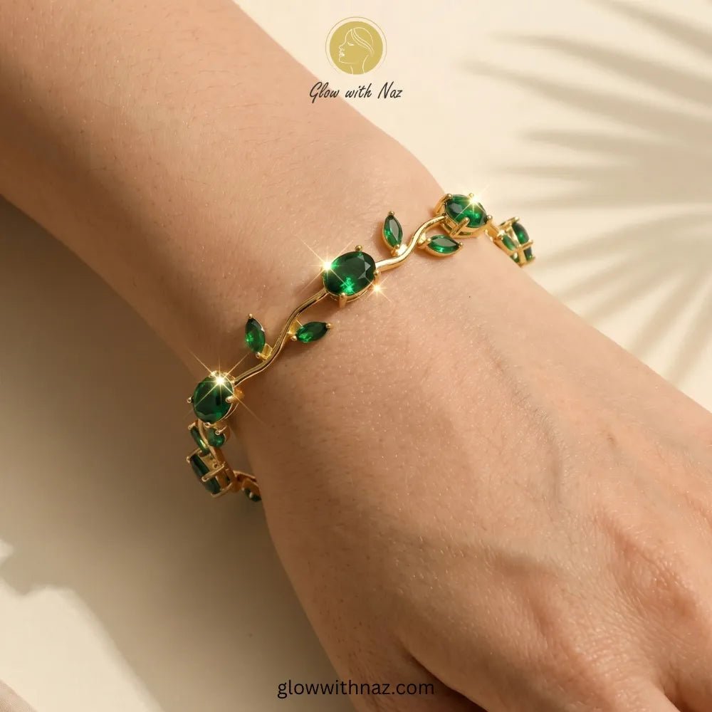 Premium Green Tulip Bracelet | Rapunzel Floral Stainless Steel Bracelet - Premium Green Tulip Bracelet | Rapunzel Floral Stainless Steel BraceletJewelryGlow With NazGlow With NazTB003AA gold bracelet with green gemstone leaves and oval emerald-cut stones, shown worn on a person's wrist against a warm beige background with soft leaf shadows. Tulip Rapunzel bracelet, floral tulip bracelet, Rapunzel inspired jewelry, aesthetic tulip bracelet, trendy charm bracelet, stainless steel tulip bracelet, g