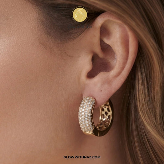 Premium Statement Zircon Crystal Hoop Earrings for Women - Premium Statement Zircon Crystal Hoop Earrings for WomenJewelryGlow With NazGlow With NazE031A close-up of a model's ear wearing a gold huggie hoop earring paved with small clear stones, with a matching gold stud earring in the opposite ear. The brand name 'GLOWWITHNAZ. studs earrings, small earrings, girls earrings, simple earrings, earrings for girls, black earrings, earrings, ear rings, earrings tops, stud earrings, tops earrings, aes