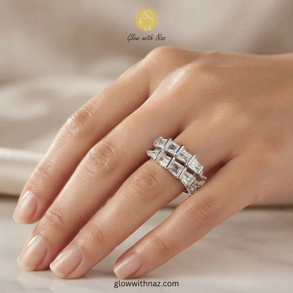 Radiant Adjustable Silver Arrow Diamond Ring - Radiant Adjustable Silver Arrow Diamond RingJewelryGlow With NazGlow With NazR028A close-up of a hand wearing a silver-toned ring with a row of clear baguette-cut gemstones. The image has 'Glow with Naz' branding at the top and 'glowwithnaz. ring, girls rings, rings for girls, rings simple, simple rings, stainless steel jewelry, jewellery set, aesthetic jewelry, simple jewellery, chain, jewelry, artificial jewellery