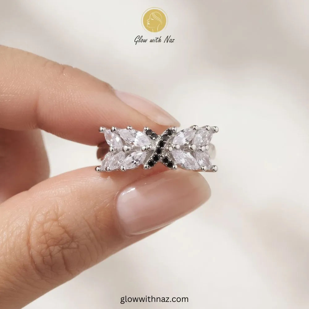 Silver marquise crystal ring with black pave cross emblem held in hand by Glow With Naz