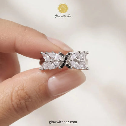Silver marquise crystal ring with black pave cross emblem held in hand by Glow With Naz