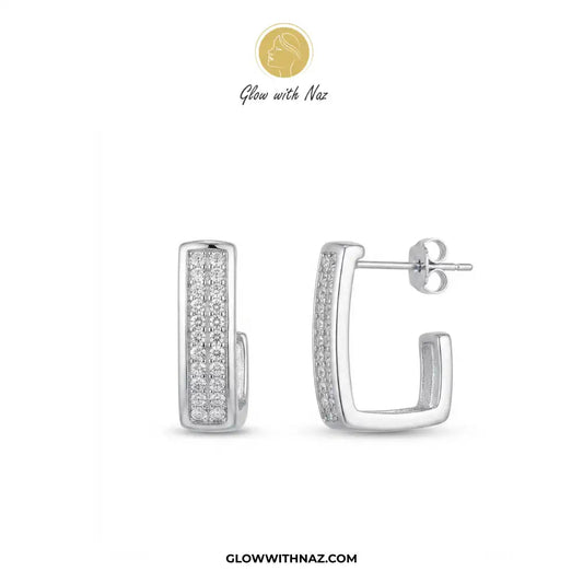 Silver Zircon Square Statement Earring for Women - Silver Zircon Square Statement Earring for WomenJewelryGlow With NazGlow With NazE054A pair of silver-toned huggie hoop earrings with pavé-set clear stones, shown from front and side angles on a white background. The brand logo 'Glow with Naz' is displayed at the top, and the website 'GLOWWITHNAZ.
