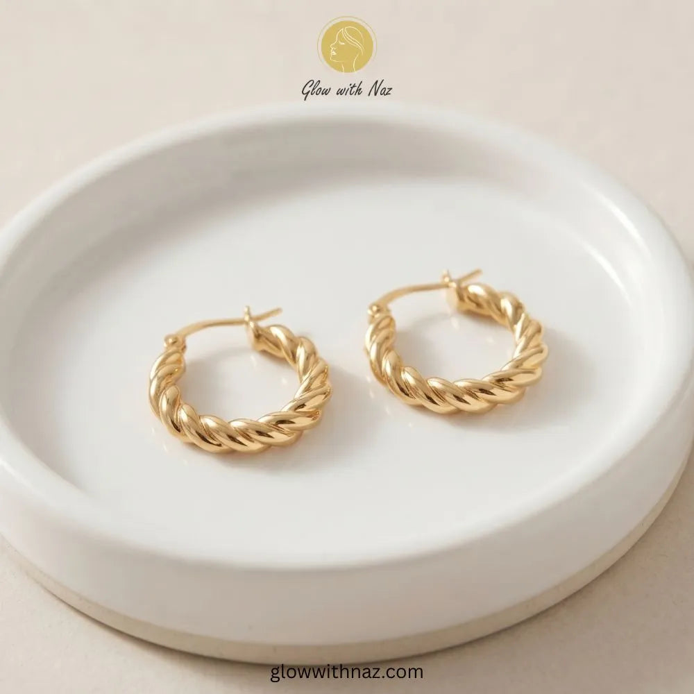 Pair of gold thick twisted baali stainless steel hoop earrings by Glow With Naz