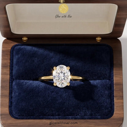 Timeless Adjustable Gold Plated Oval Diamond Ring - Timeless Adjustable Gold Plated Oval Diamond RingJewelryGlow With NazGlow With NazR020A yellow gold ring with a large round brilliant-cut diamond solitaire is displayed in an open wooden jewelry box with a dark blue velvet interior. The inside lid features the brand name 'Glow with Naz' in gold script on a cream background. ring, girls rings, rings for girls, rings simple, simple rings, stainless steel jewelry, jewellery set, aesthetic jewelry,