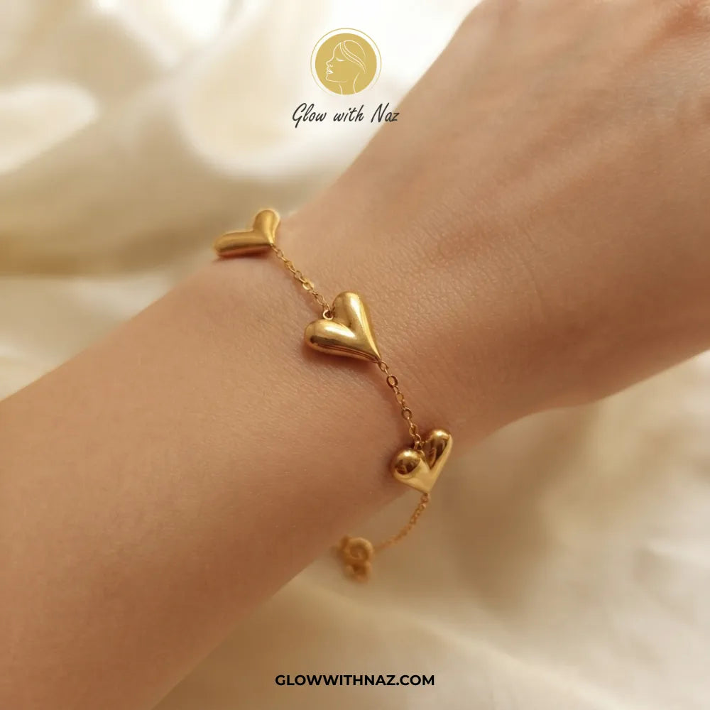 Trio puffed balloon heart gold bracelet worn on model wrist by Glow With Naz