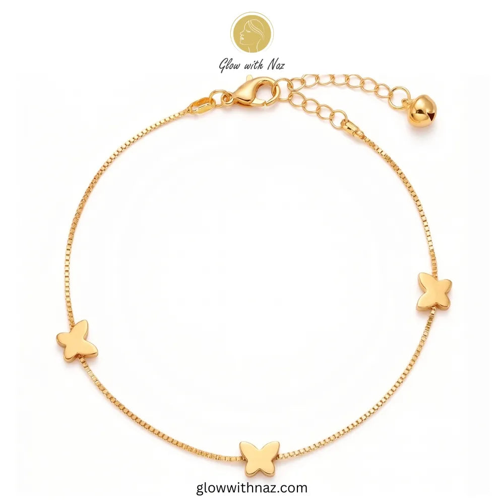 Close-up of a woman's ankle wearing a stunning, minimalist gold butterfly anklet with polished butterfly motifs